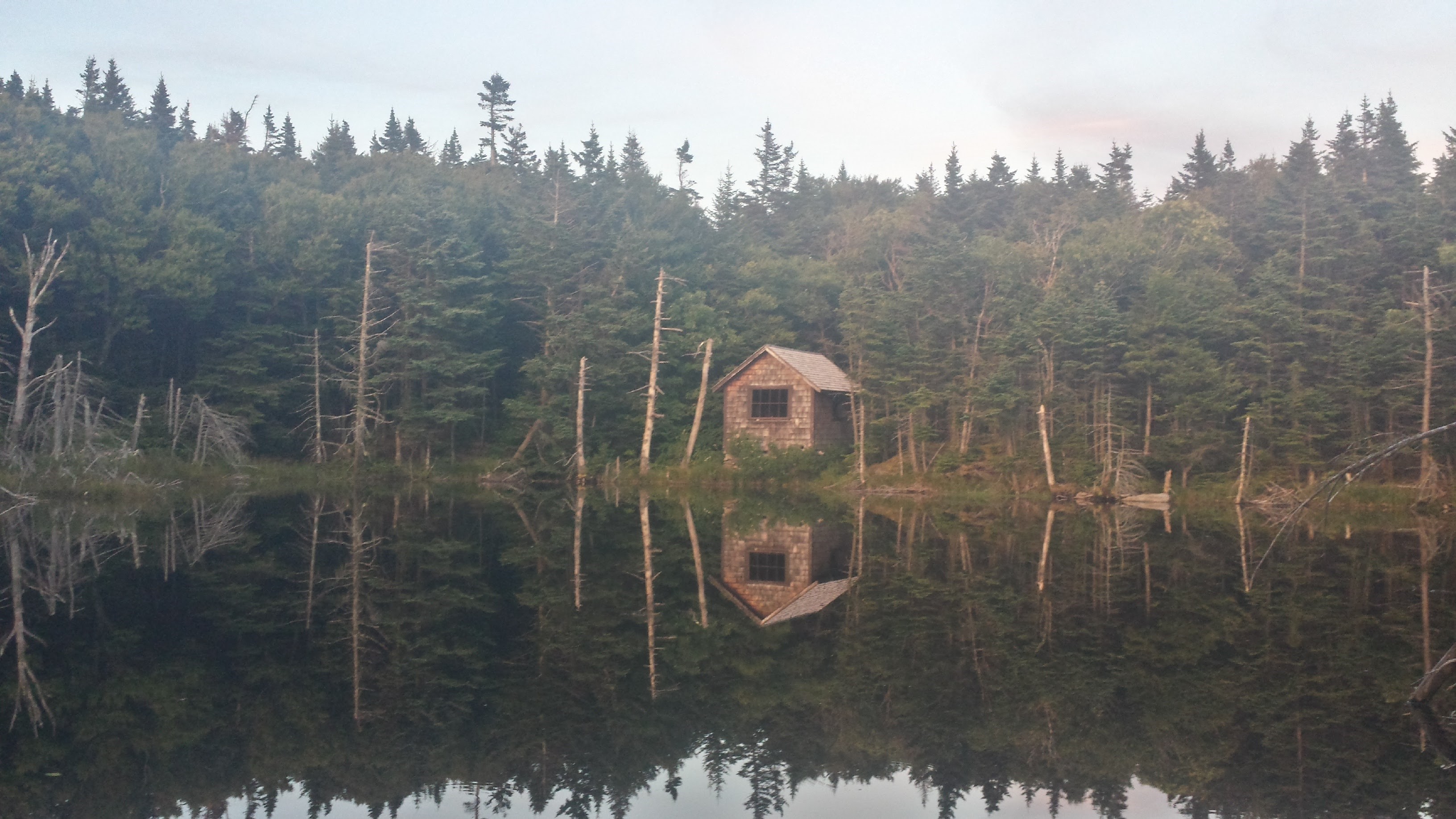 a lake with an old cabin in vermont